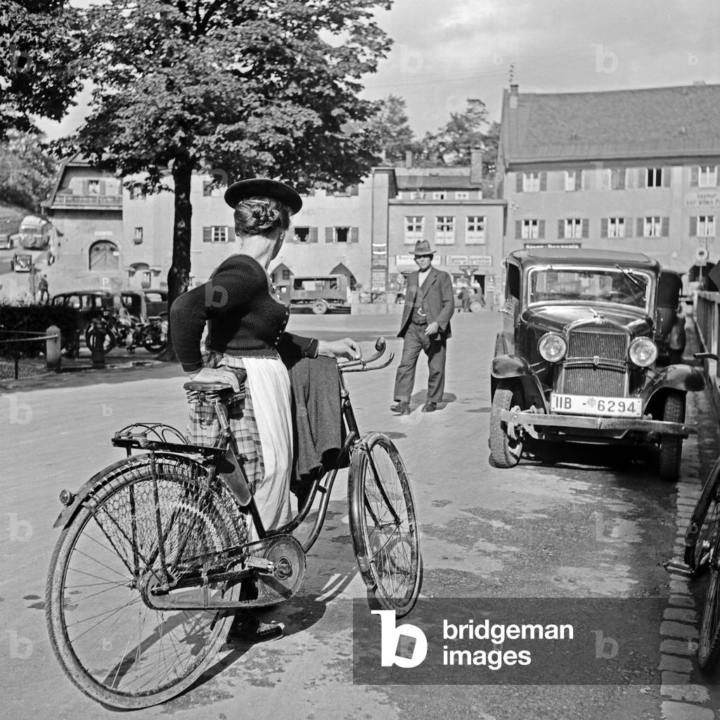 Passers by at Miesbach, on their way by foot, by car or by bicycle, Germany 1930s (b/w photo)