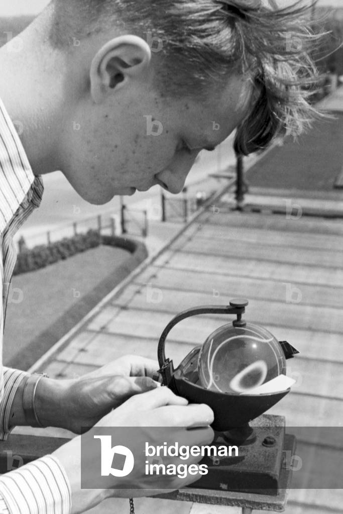Staff member of a meteorological office calibrating analyser, Germany 1930s (b/w photo)