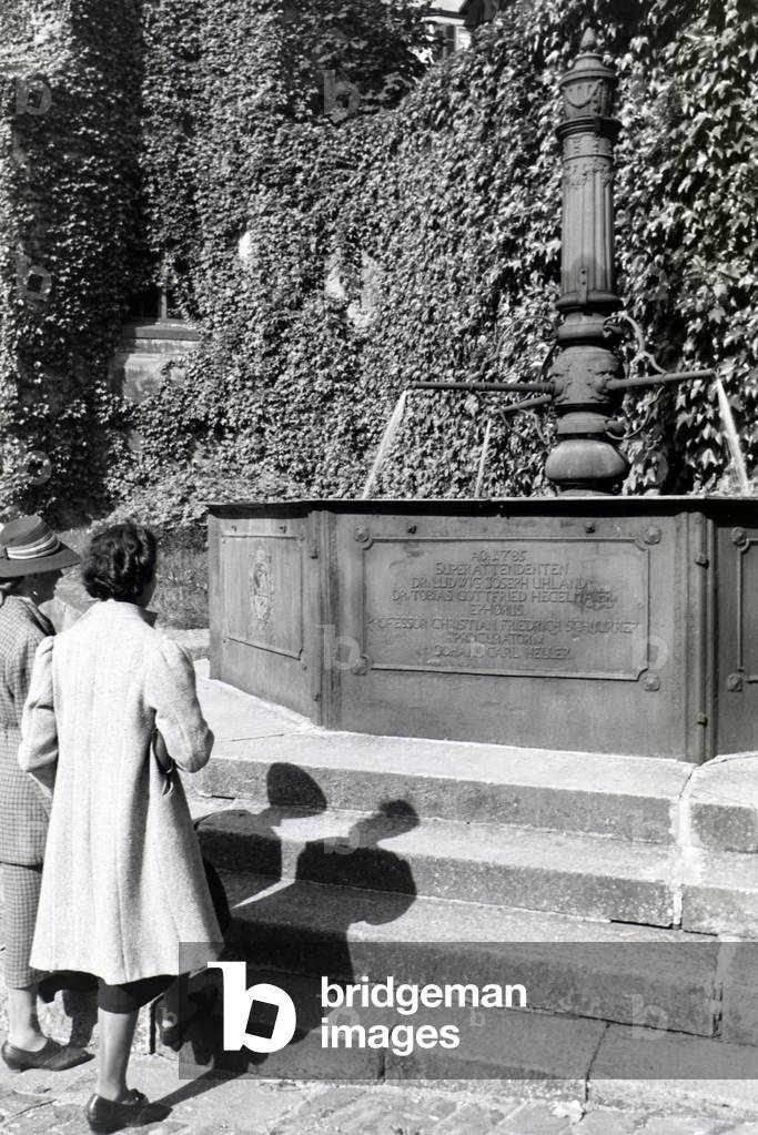The water well with inscription on the patio of the Protestant church foundation, Tübingen, Germany 1930s (b/w photo)