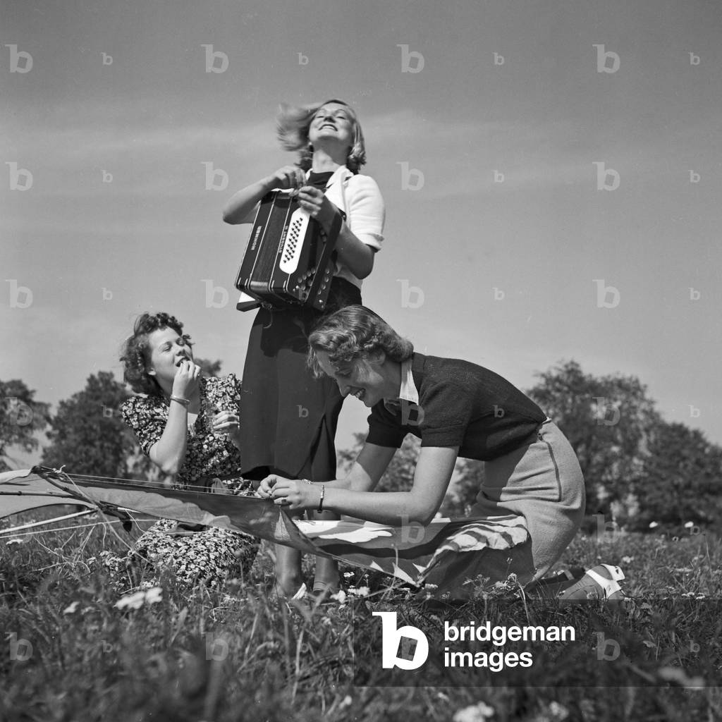 Three women playing music with an accordion, Germany 1930s (b/w photo)