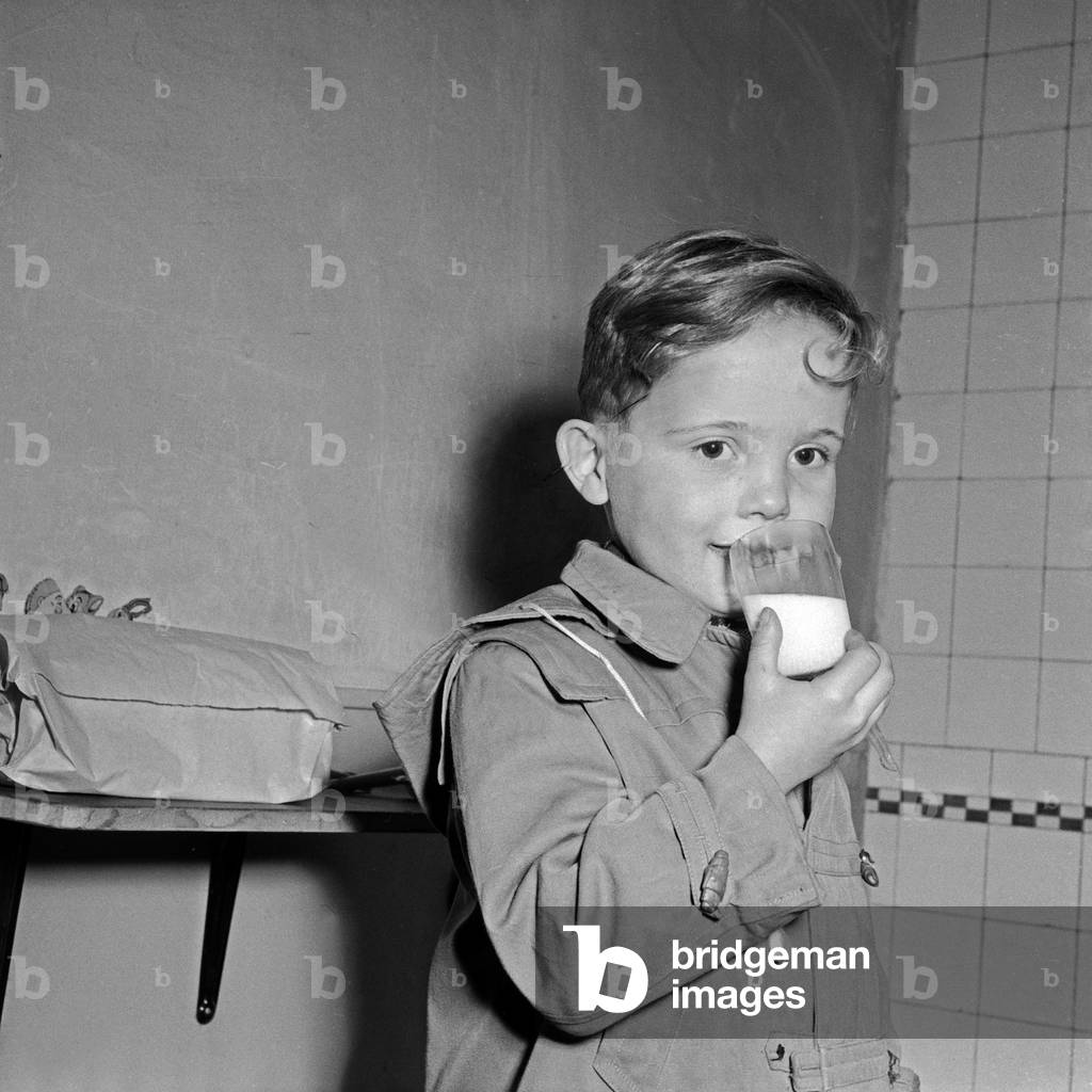A little boy drinking a glass of milk, Germany 1950s