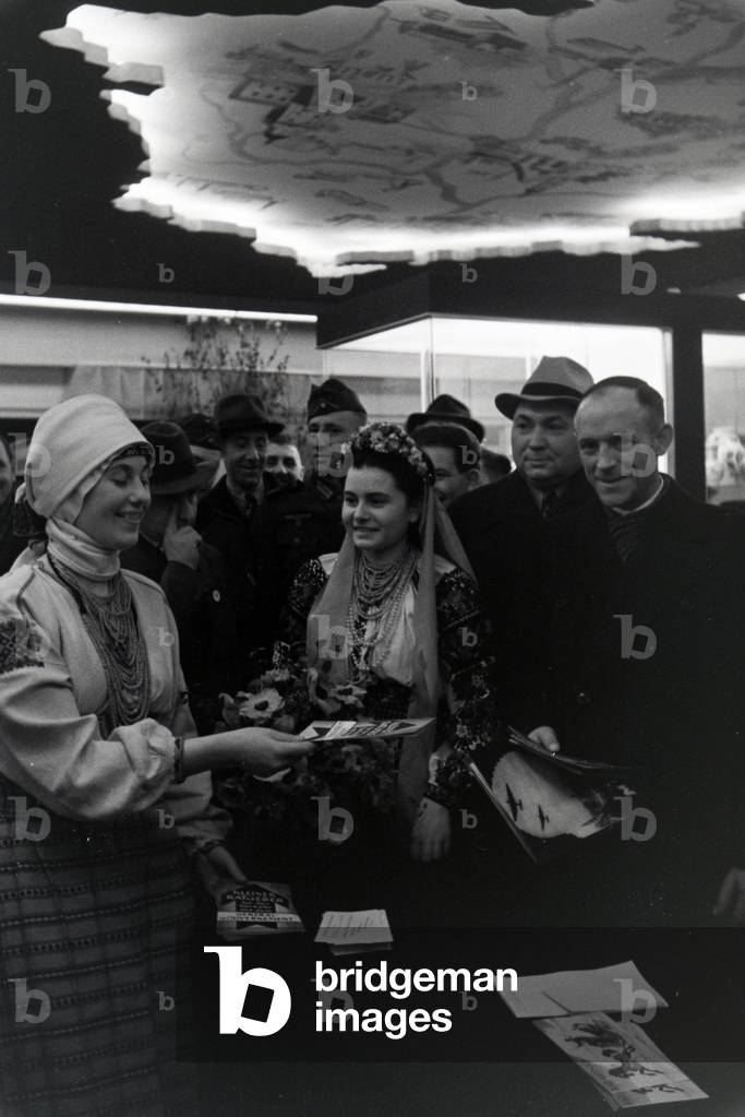 Visitors in front of a information desk of the Leipziger Frühjahrsmesse, Germany 1941 (b/w photo)