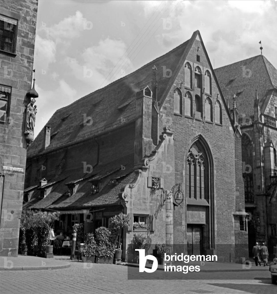 The snack bar Bratwurstgloecklein beside the Moritz chapel at the Albrecht Duerer square in the old city of Nuremberg, Germany 1930s (b/w photo)
