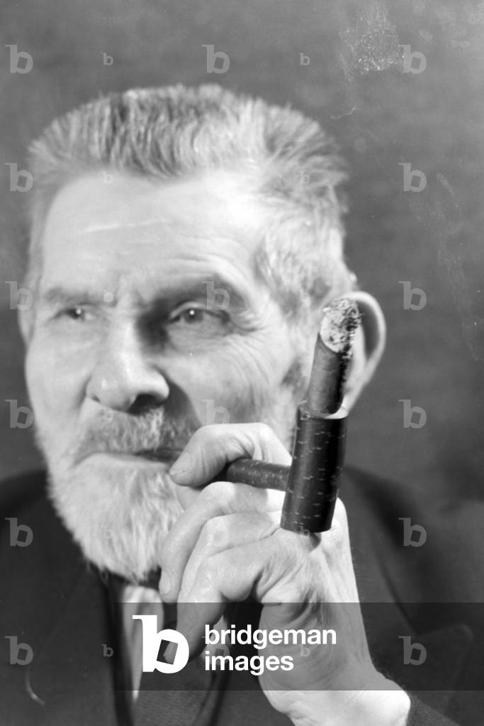 A man smoking a cigar for an advertising campaign, Germany 1930s (b/w photo)