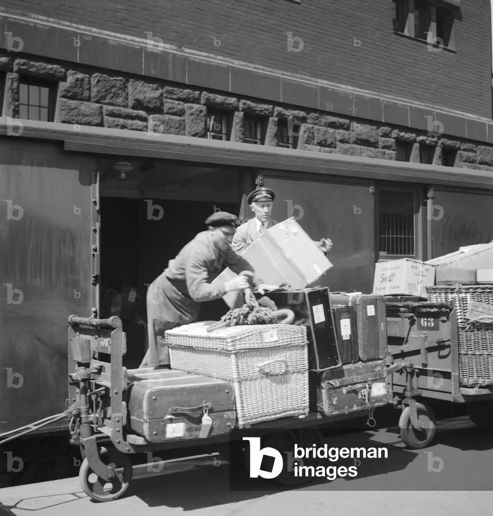 Baggage porter at a platform of Hamburg main station, Germany 1930s (b/w photo)