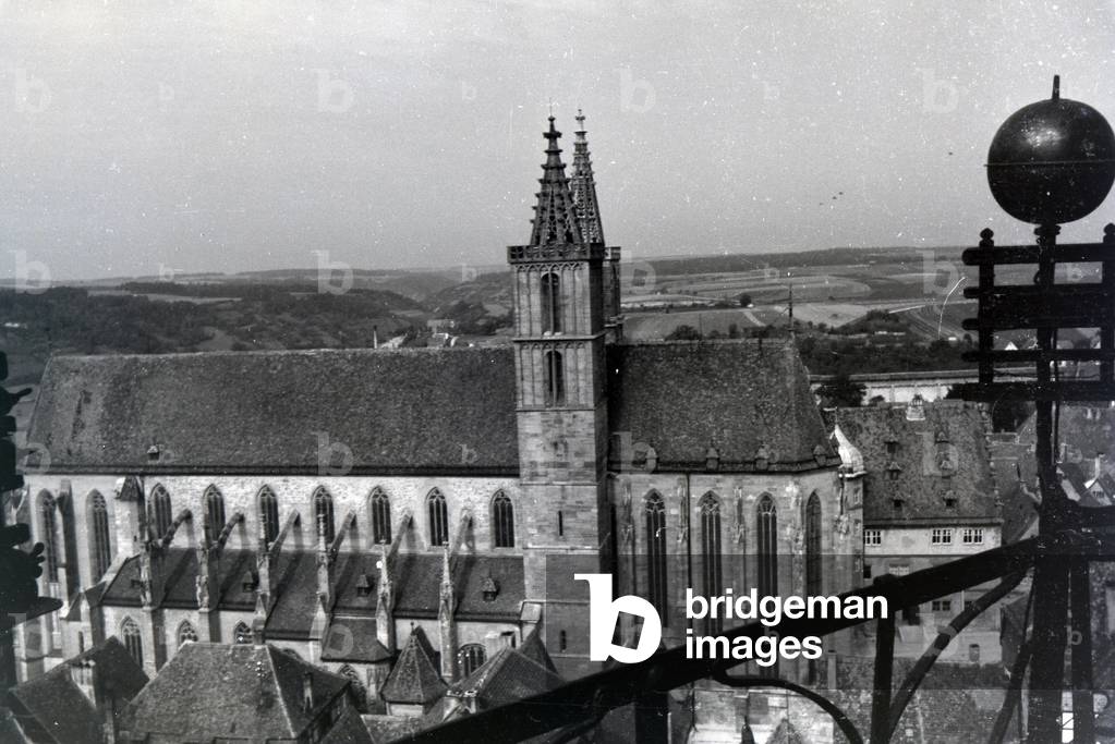 The highest tower of the townhall presents an excellent view of the parish church St Jakob in Rothenburg ob der Tauber and the surrounding natural landscapes, Germany 1930s (b/w photo)
