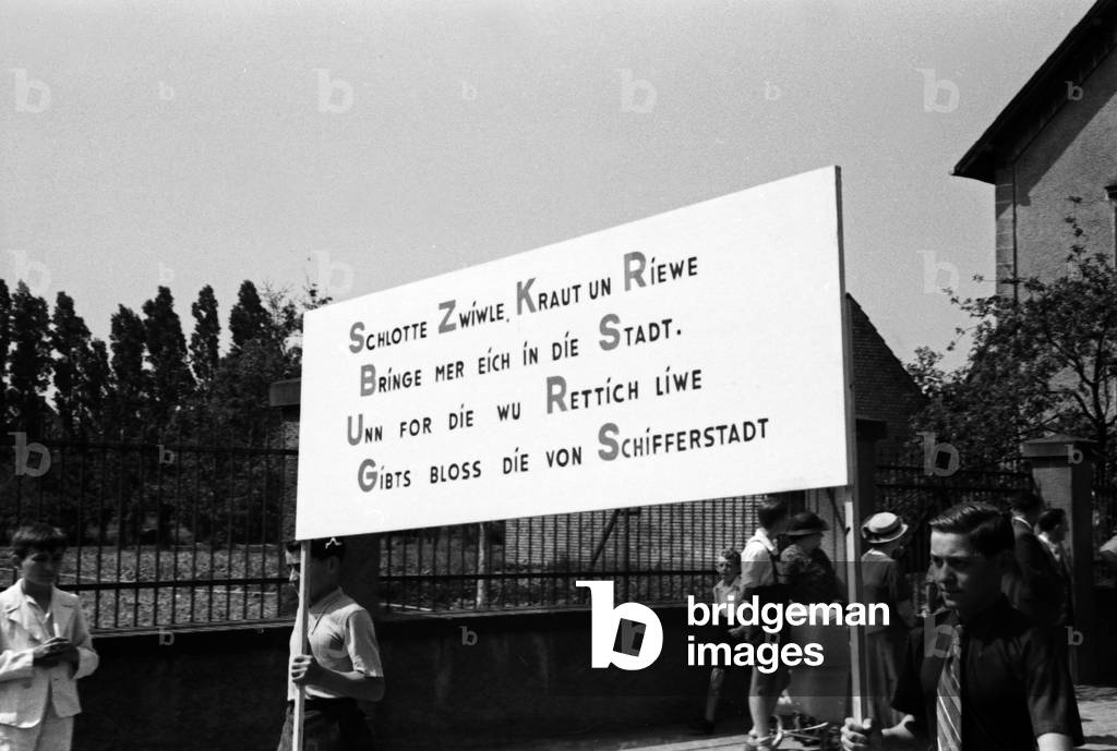 Advertising slogan for radish at the pageant at the annual radish fair at Schifferstadt, Germany 1930s (b/w photo)