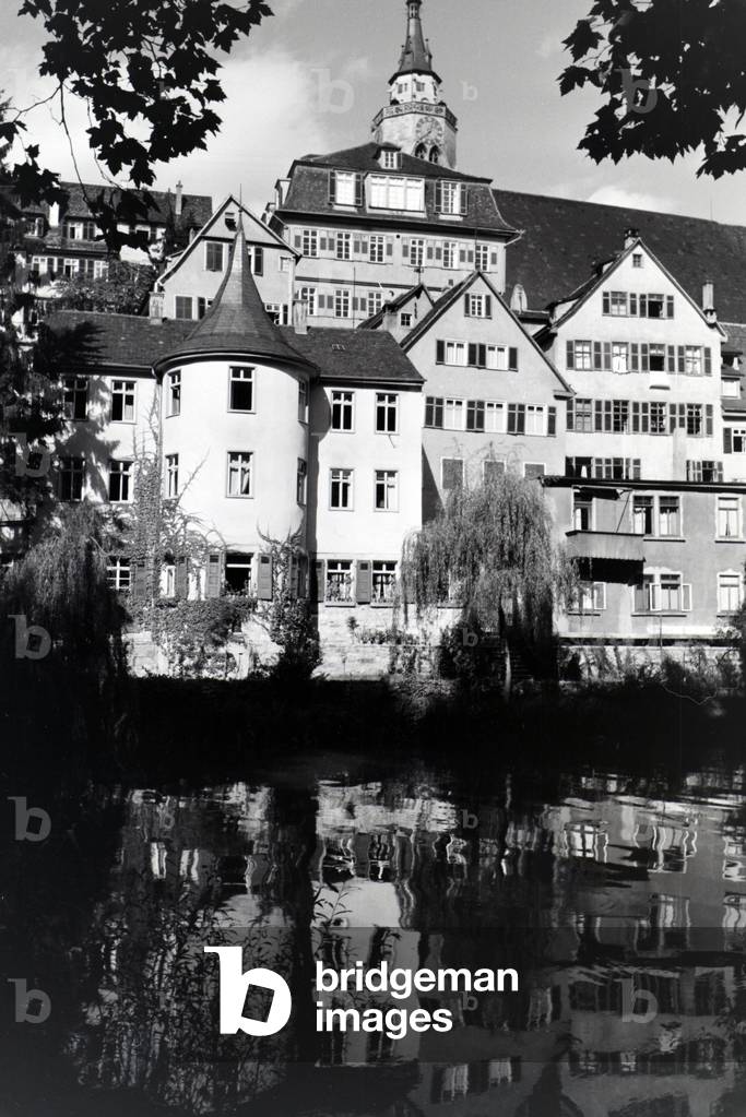 The facades of half-timbered houses along the Neckar with the collegiate church in the background in Tübingen, Germany 1930s (b/w photo)