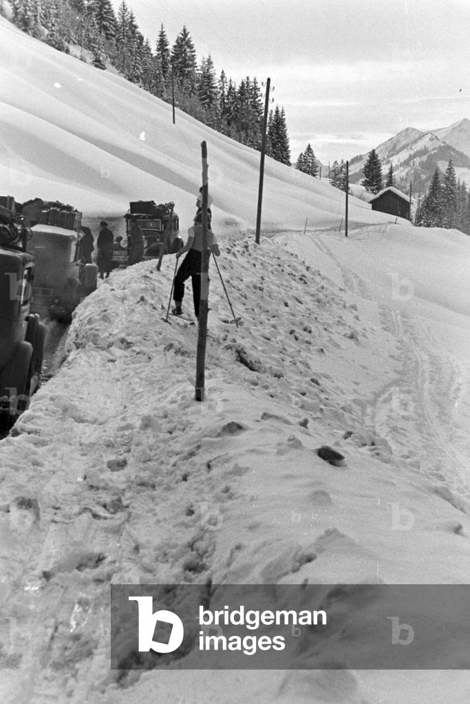 Car traffic in a snowy winter landscape, Germany 1930s (b/w photo)