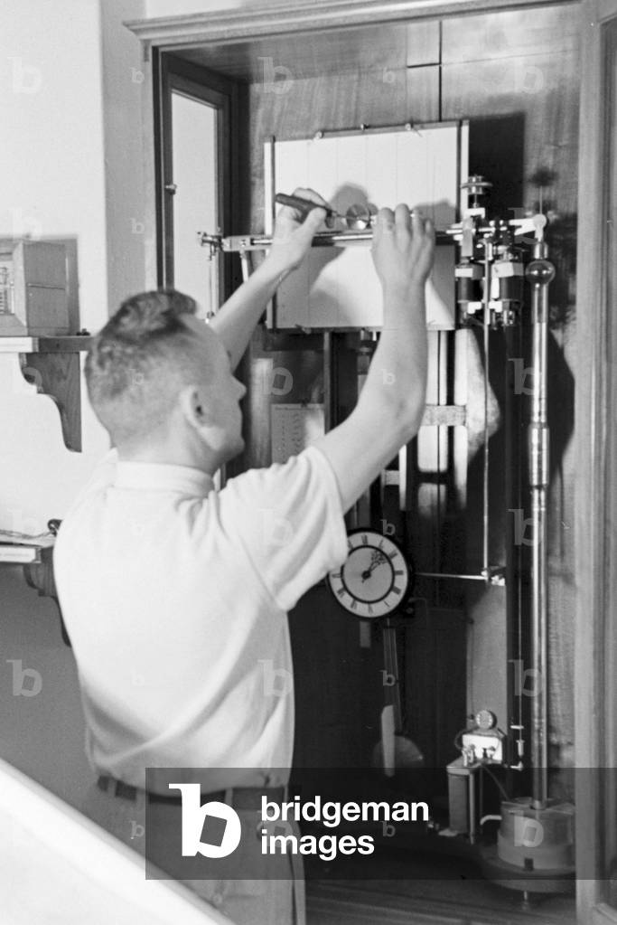 Staff member of a meteorological office calibrating analyser, Germany 1930s (b/w photo)