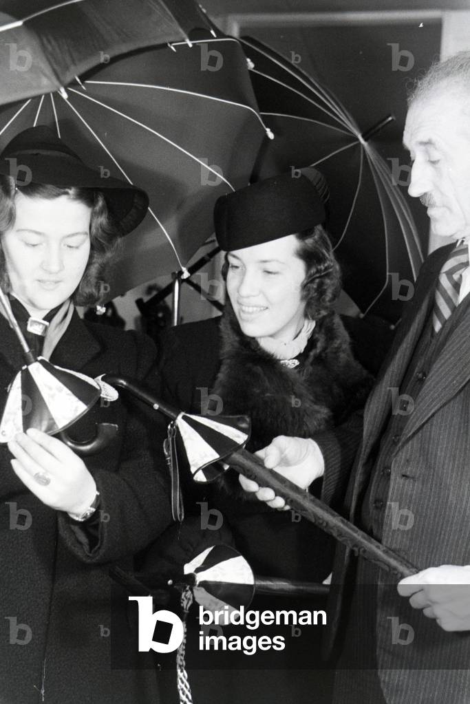 A sales assistant presenting umbrellas, on the occasion of the Wiener Modewoche in the house of fashion 