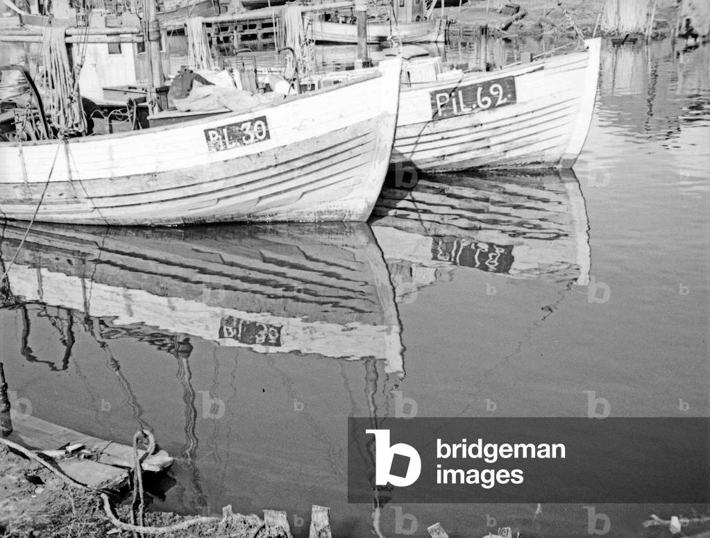 Fish trawlers waiting at the harbor for the next draught of fish, East Prussia, 1930s (b/w photo)