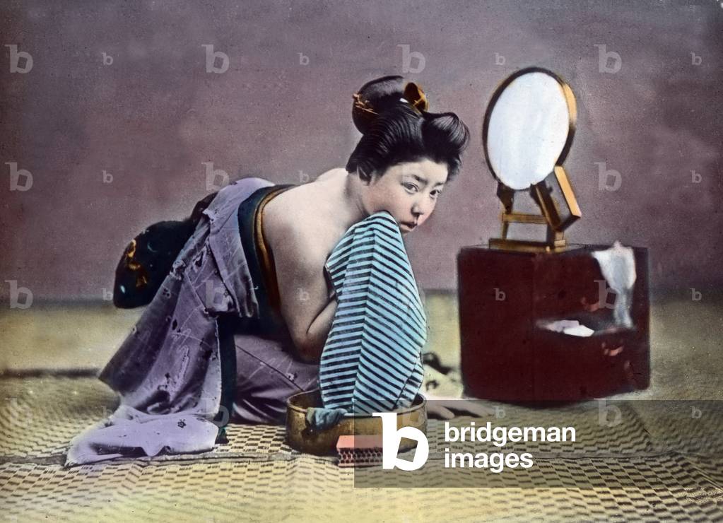 Japan, Portrait of a young woman at the morning toilette, image date: circa 1920. Carl Simon Archive