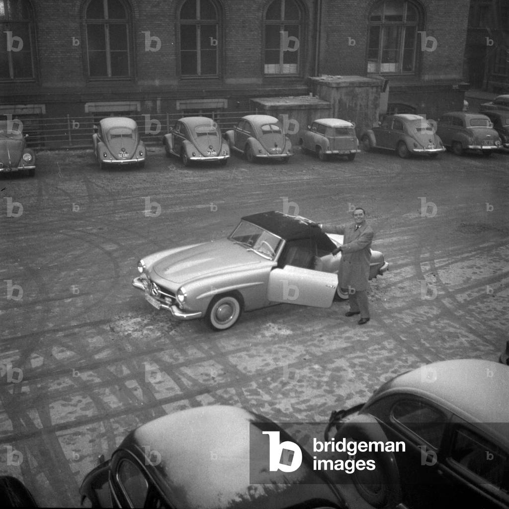 German jazz pinaist and composer Fritz Schulz - Reichel with his Mercedes Benz 190 SL convertible at the parking area of TV and radio station NWDR, Hamburg 1955