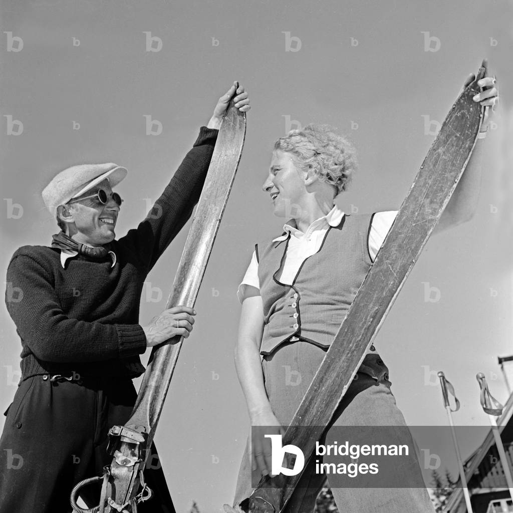 Two ski tourists talking shop about their skis, Germany 1930s (b/w photo)