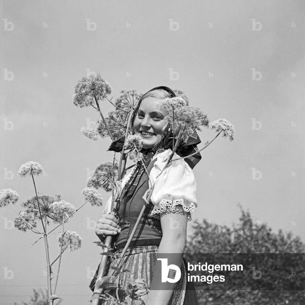 A young woman climbing on a mountain in the Wachau area in Austria, Germany 1930s (b/w photo)