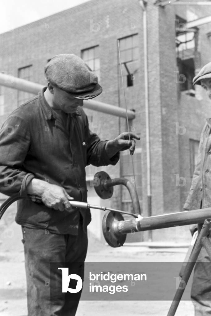 A welder bonding different components, Witten, Germany 1930s (b/w photo)