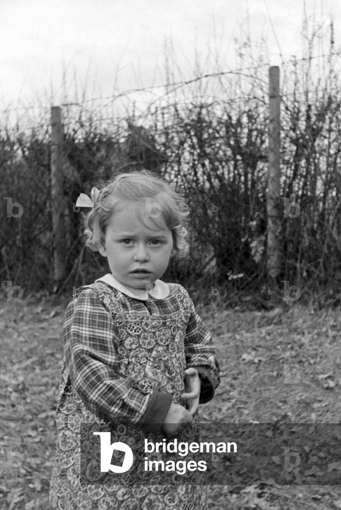 One of Knipser's quadruplet girls playing at the garden, Germany 1930s (b/w photo)