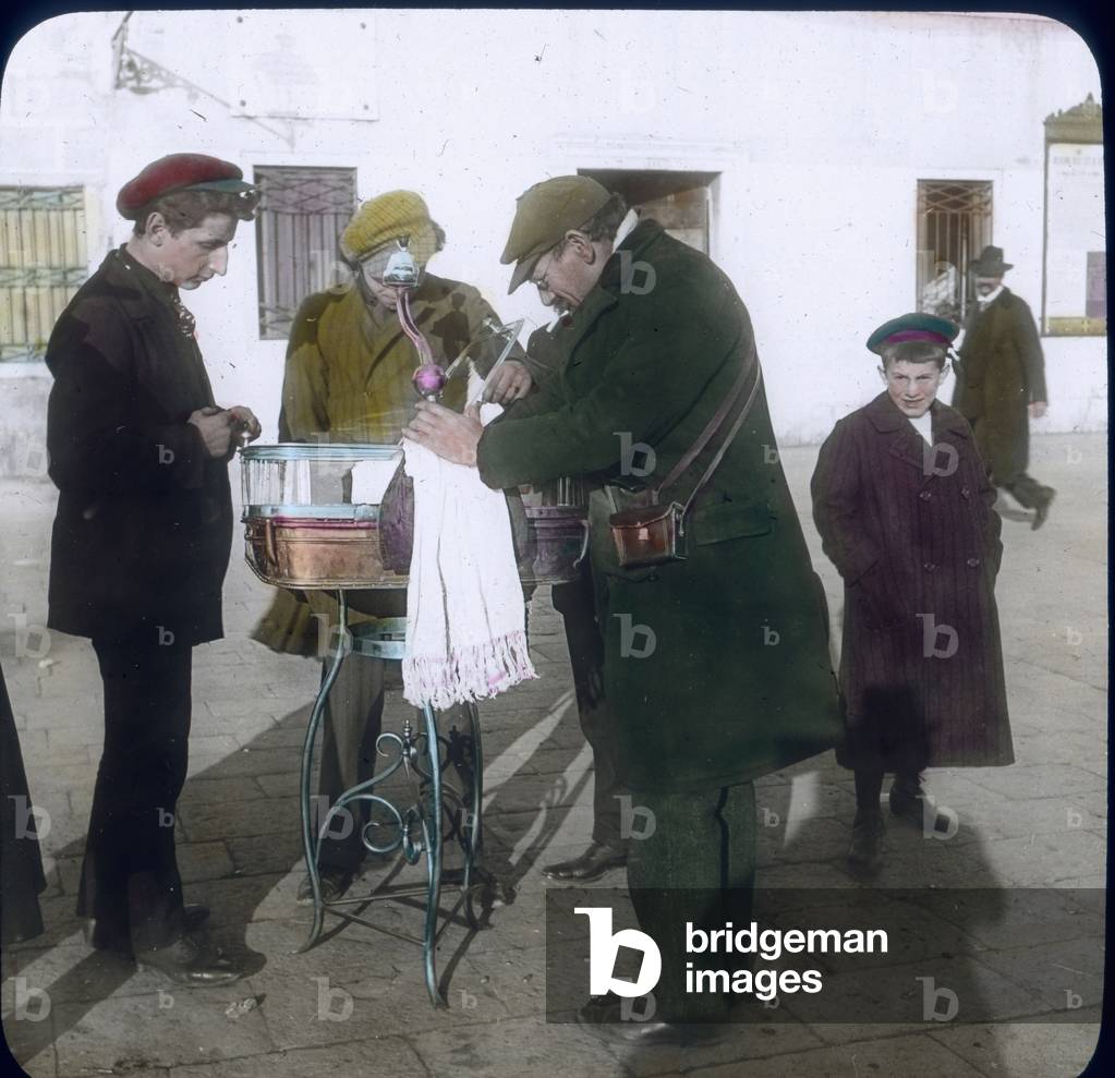 Italy, Venice, street seller with customers, image date: circa 1910. Carl Simon Archive