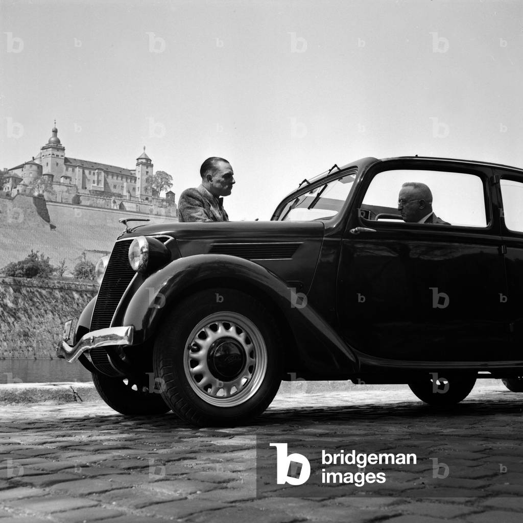 Two men with a compact car in front of the Marienberg fortress at Wuerzburg, Germany 1930s (b/w photo)