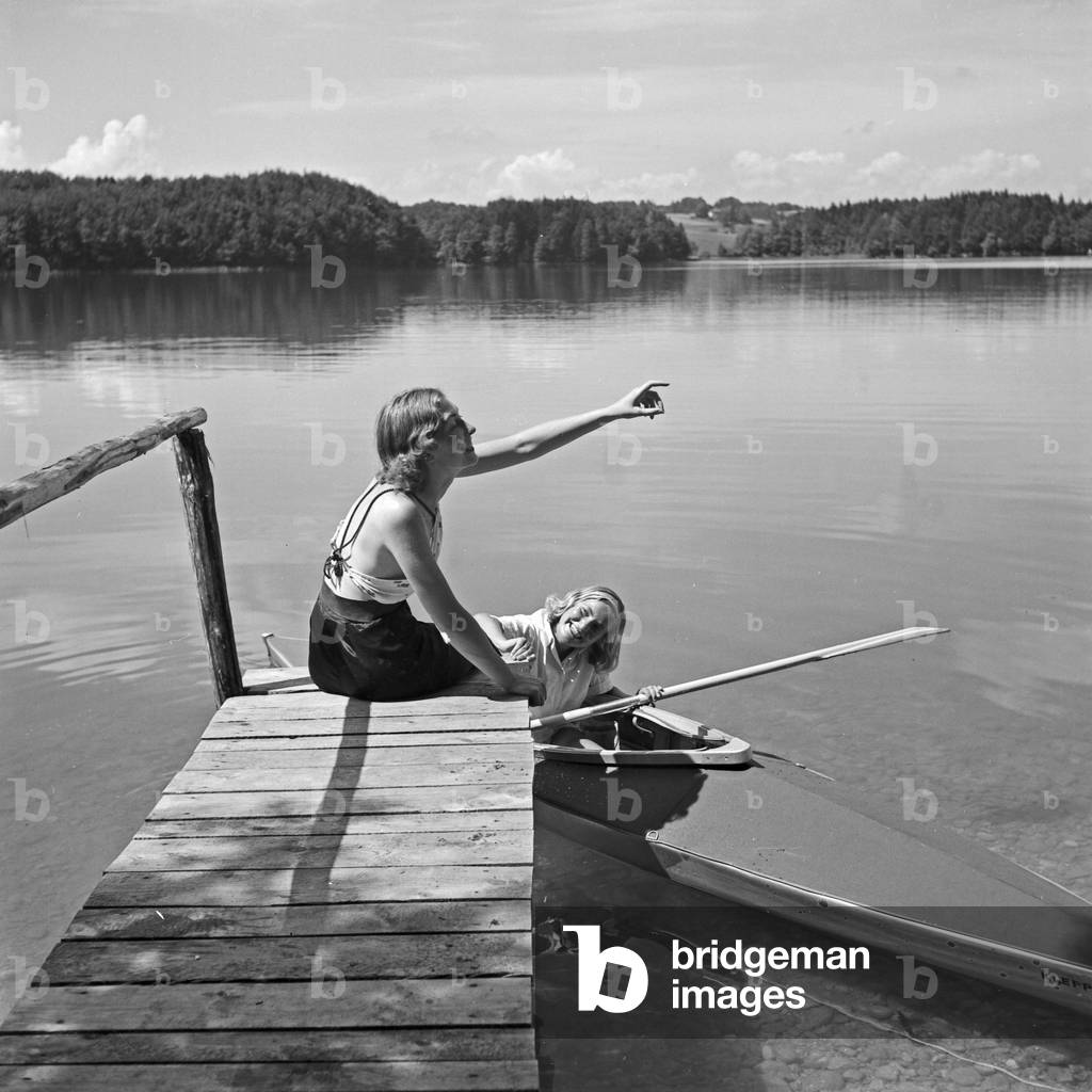 Two young women at a boardwalk on the shore of a lake in the Wachau area, Germany 1930s (b/w photo)