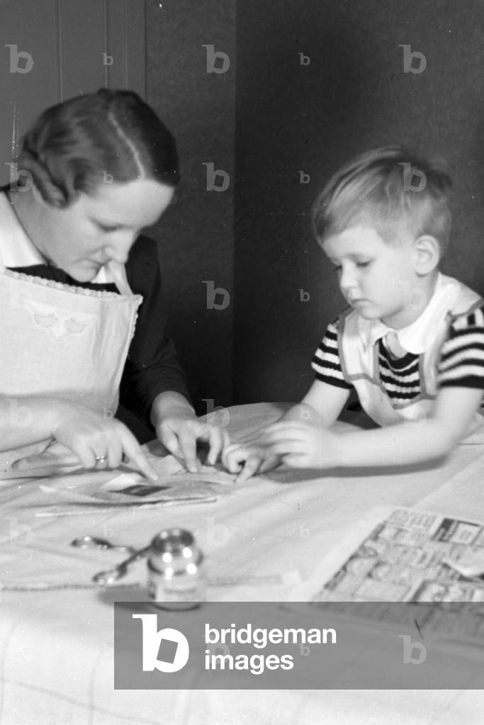 Mother and child doing handicrafts, Germany 1930s (b/w photo)