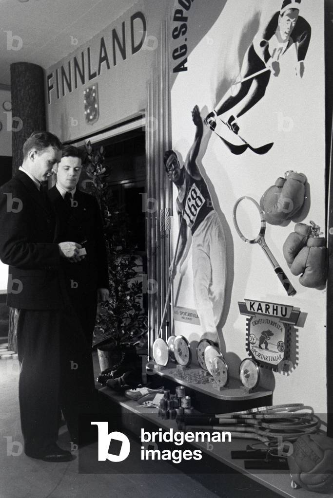 Two Visitors in front of a stand of finnish sports goods on the Leipziger Frühjahrsmesse, Germany 1941 (b/w photo)