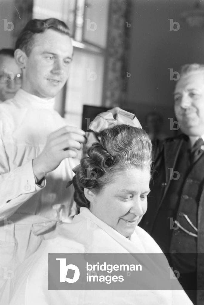 A hairdresser preparing a hairdo at Haus der Schoenheit beauty salon, Germany 1930s (b/w photo)