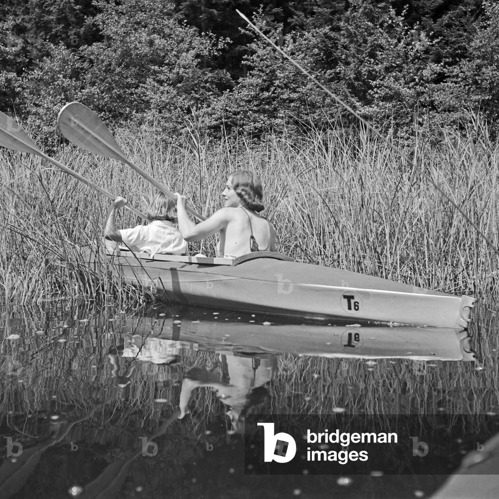 Two young women at a boardwalk on the shore of a lake in the Wachau area, Germany 1930s (b/w photo)