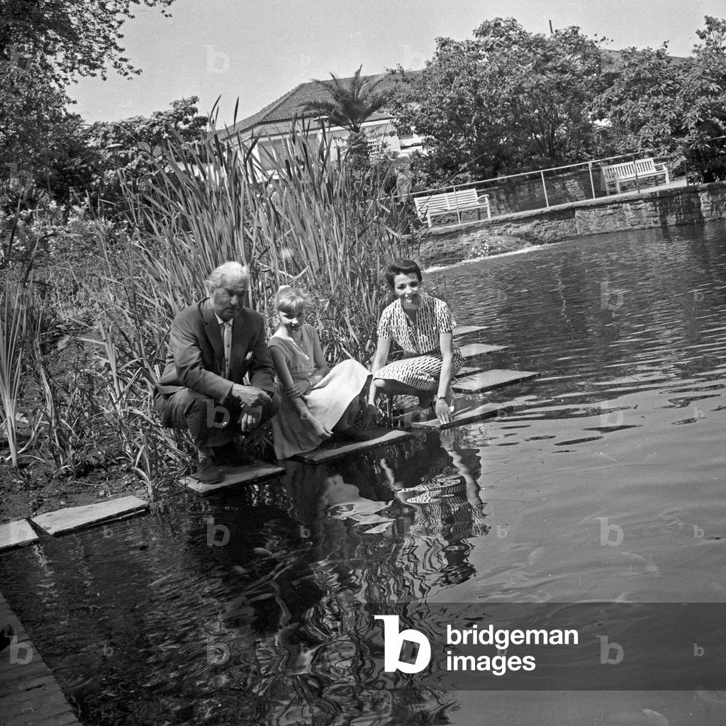 German television announcer Irene Koss with a child from Berlin at Planten un Blomen public gardens in Hamburg, Germany 1950s
