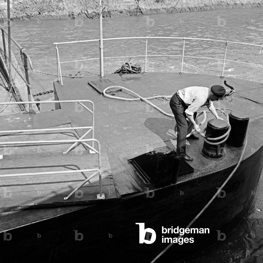 Boatman fixing the ship at the ponton, Germany 1930s (b/w photo)