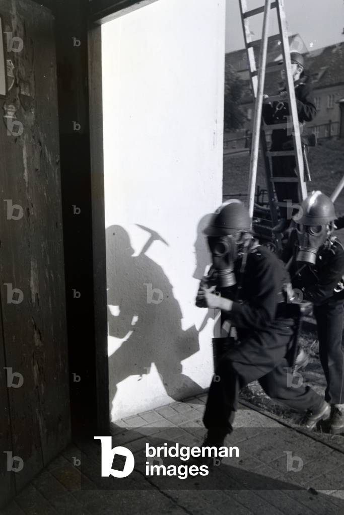 A boy with a smoke mask, protective mask during a training of the junior firefighters, Germany 1930s (b/w photo)