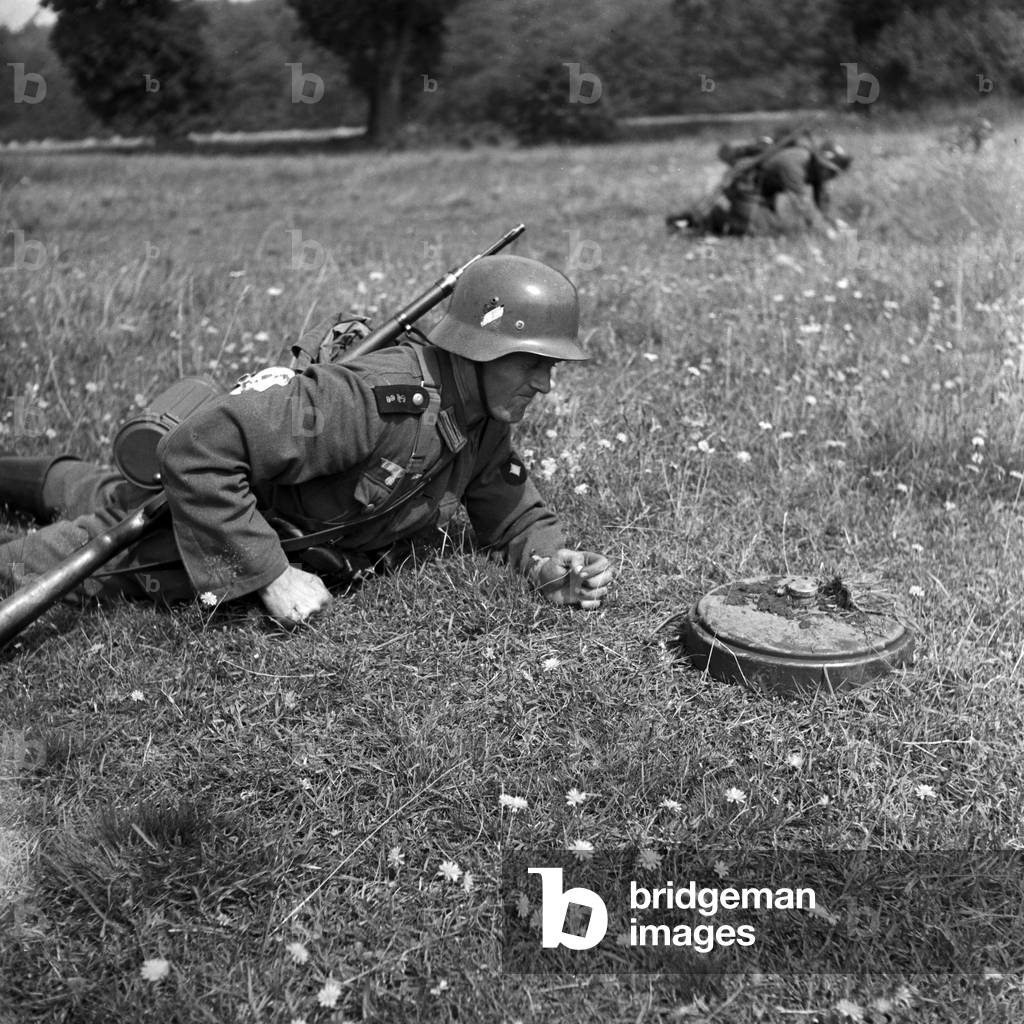 Soldiers of a military engineering unit waiting to unlock landmines after storming into their emplacement, Germany 1940s (b/w photo)