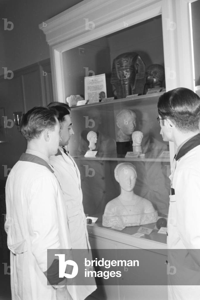Male staff members with beauty idols of world history at Haus der Schoenheit beauty salon, Germany 1930s (b/w photo)