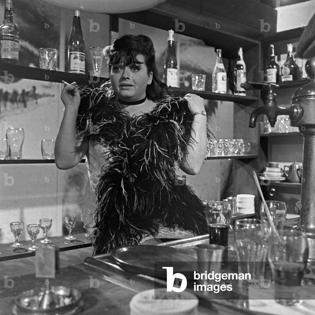 German actress, singer and later theatre manager Trude Herr playing a barmaid, 1960s