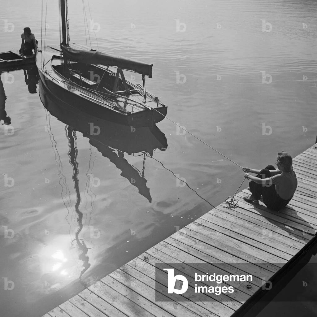 Two young women at a boardwalk on the shore of a lake in the Wachau area, Germany 1930s (b/w photo)