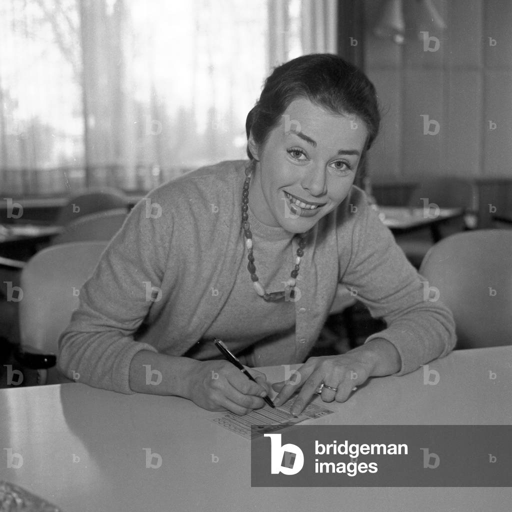 German actress Marianne Koch filling in her fee invoice at Hamburg, Germany 1956