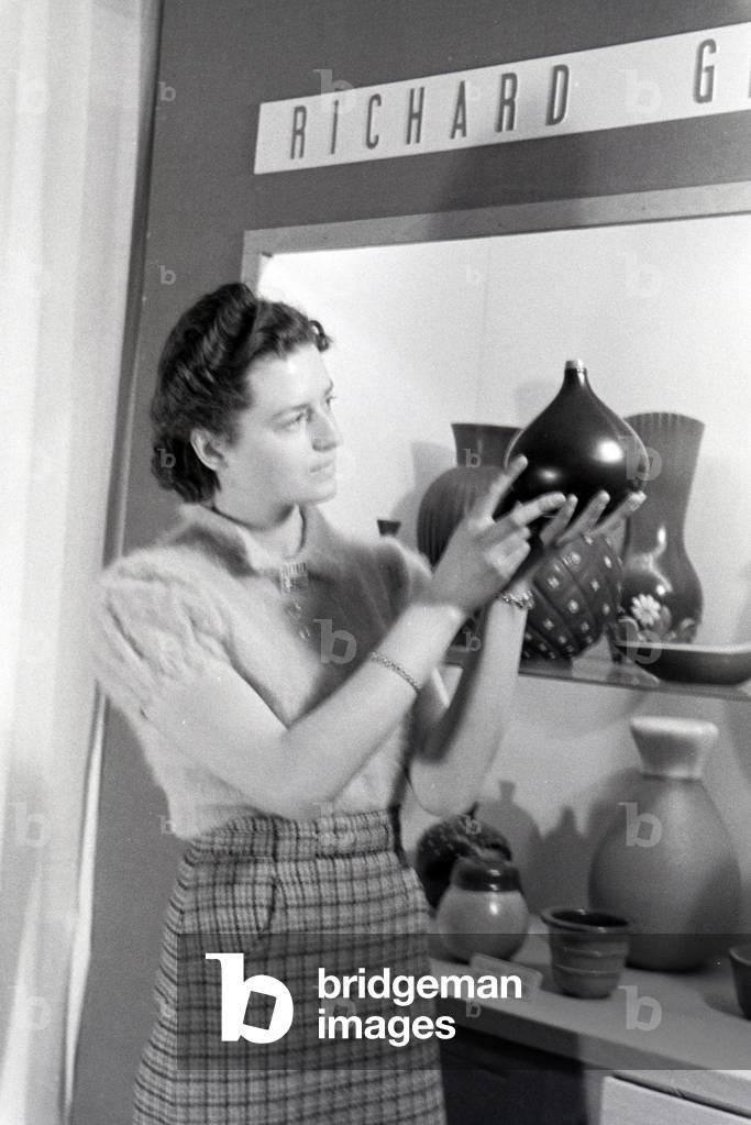 A visitor of the Leipziger Frühjahrsmesse in front of a stand of the porcelain factory Richard Ginori, Germany 1941 (b/w photo)