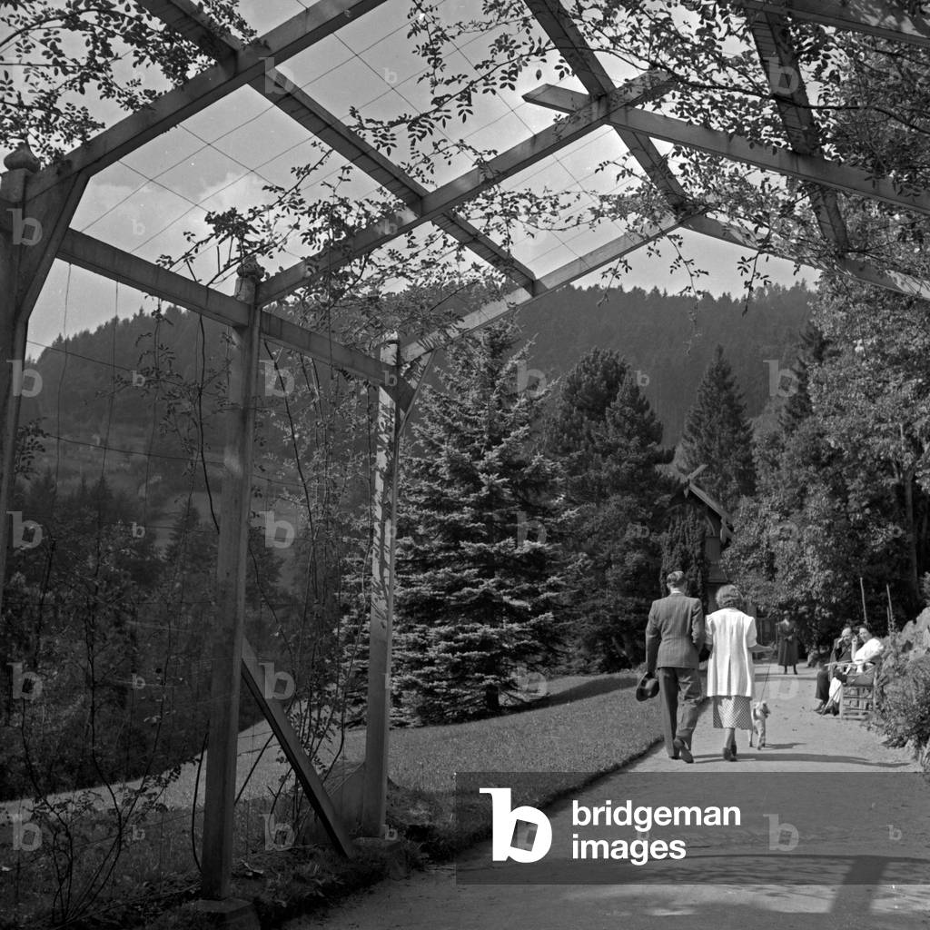 A couple strolling through an access balcony at Wildbad in Black Forest, Germany 1930s (b/w photo)