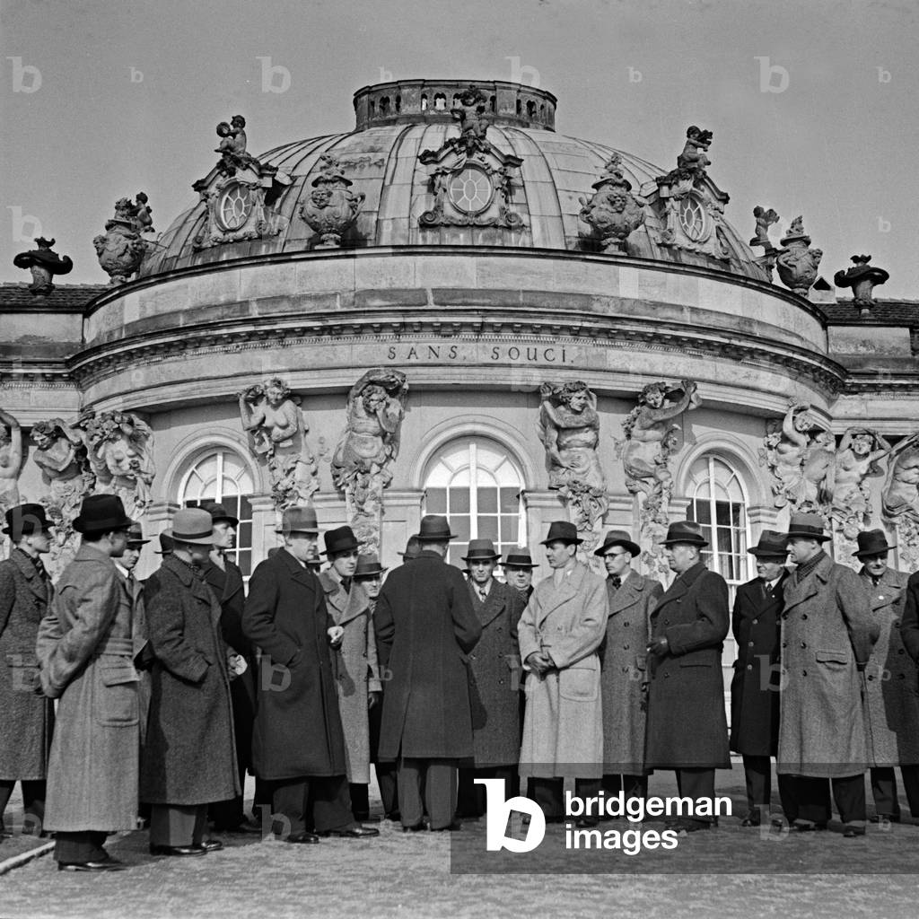 A group of travellers posing for a group photo in front if Sanssouci castle at Potsdam, Germany 1930s (b/w photo)