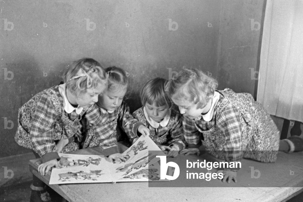 The Knipser's quadruplet girls with a storybook, Germany 1930s (b/w photo)