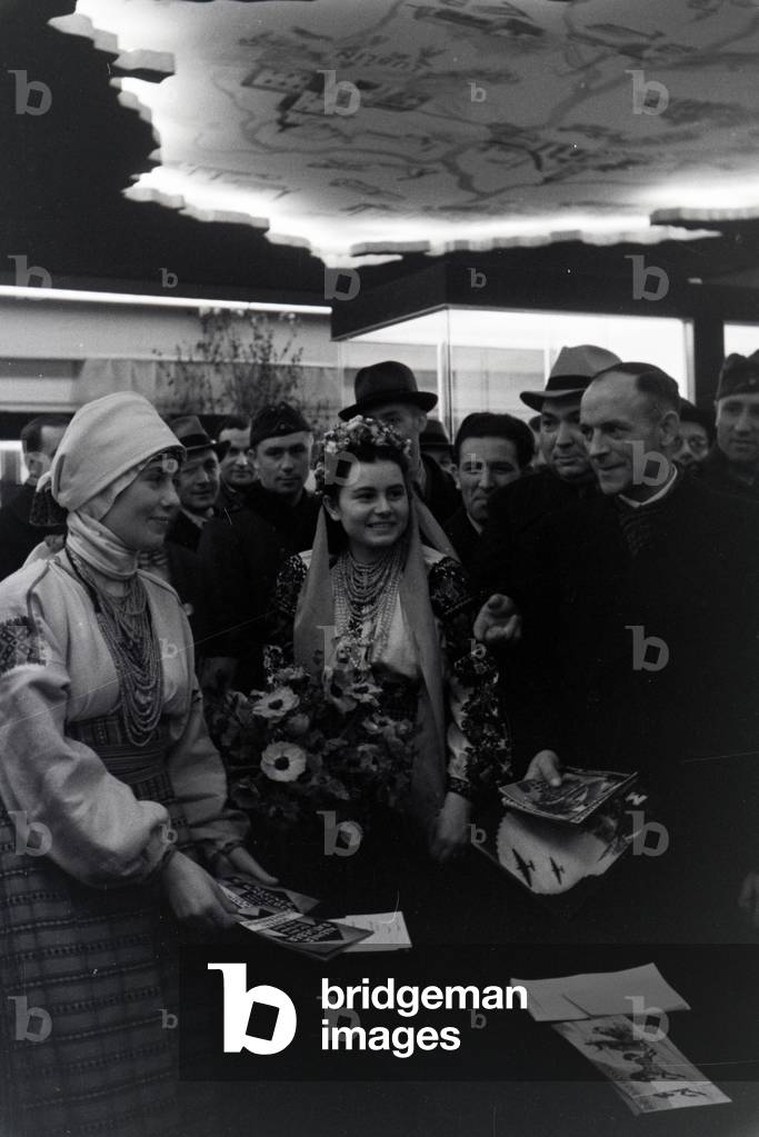 Visitors in front of a information desk of the Leipziger Frühjahrsmesse, Germany 1941 (b/w photo)