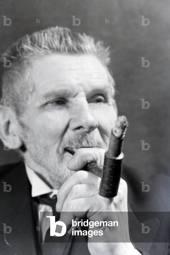 A man smoking a cigar for an advertising campaign, Germany 1930s (b/w photo)