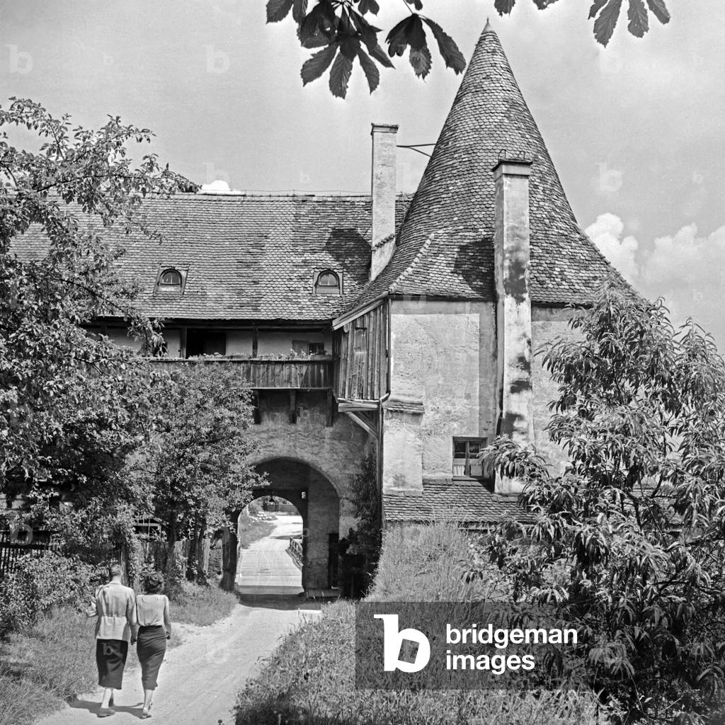 A man and a woman wandering to the old castle of Burghausen, Germany 1930s, (b/w photo)