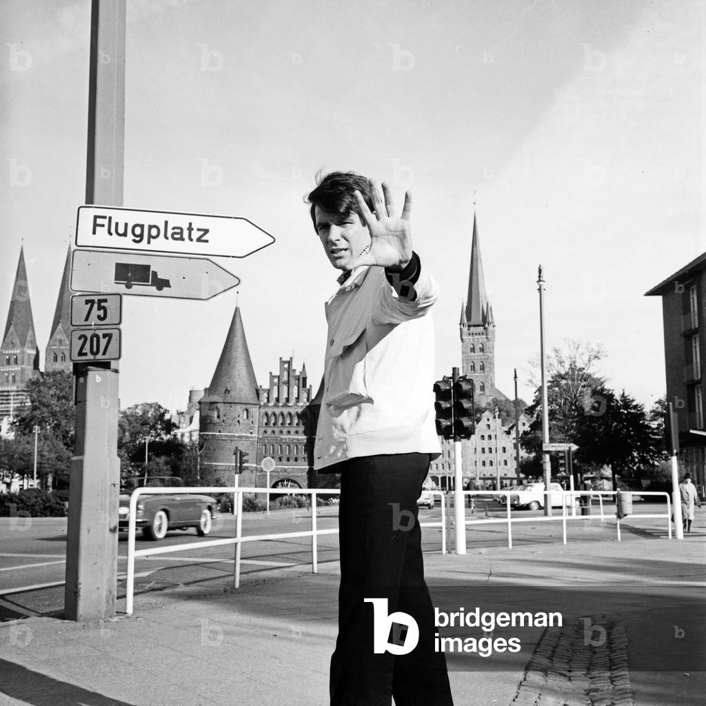 A man in front of the Holstentor gate at Luebeck, Germany 1960s