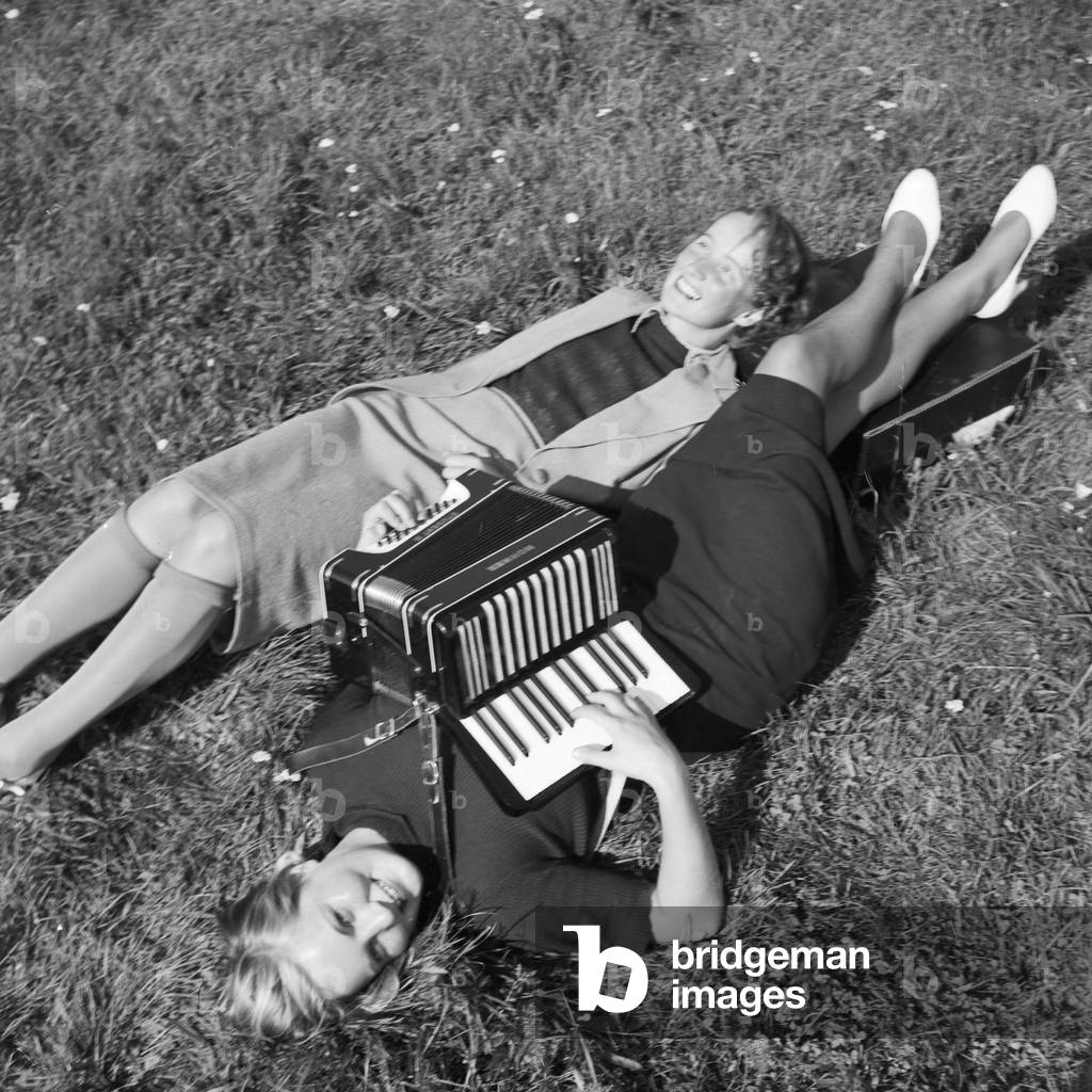 Two women playing music with an accordion, Germany 1930s (b/w photo)