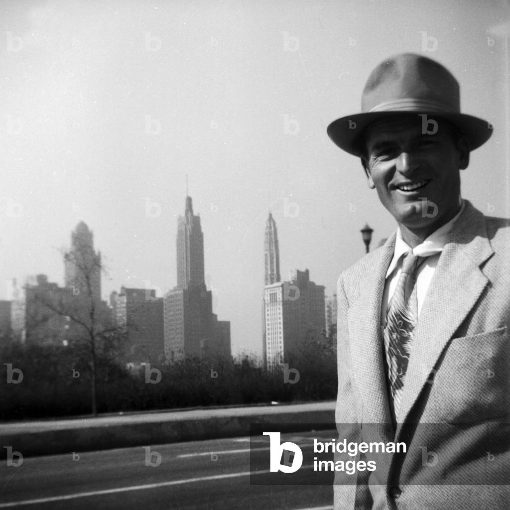 A man smiling in front of an US-American skyline, 1954