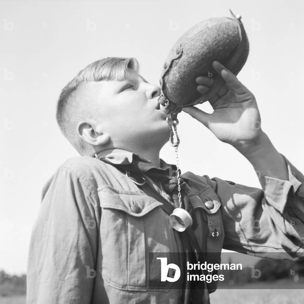 A Hitler youth drinking from his waterbottle, Germany 1930s (b/w photo)