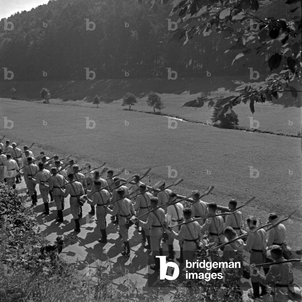 A platoon of the Reichsarbeitsdienst marching to its destination near Herrenalb in Black Forest, Germany 1930s (b/w photo)