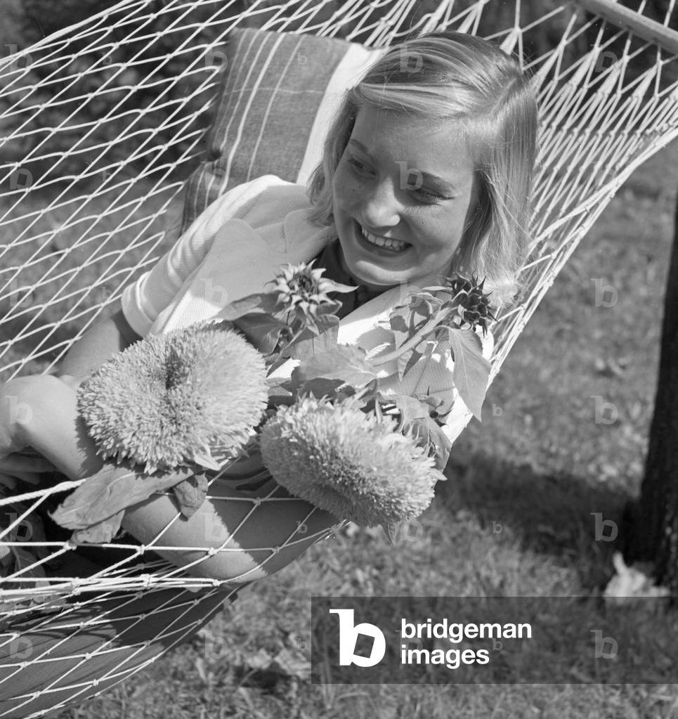 A young woman in the garden in summertime, Germany 1930s (b/w photo)